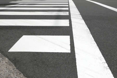 White zebra crossing on the cityscape car roadの写真素材