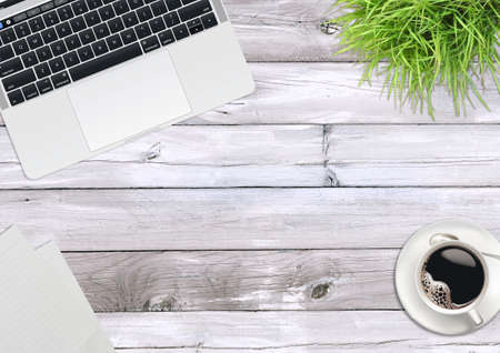 Laptop computer, green plants, coffee on the office wooden deskの写真素材