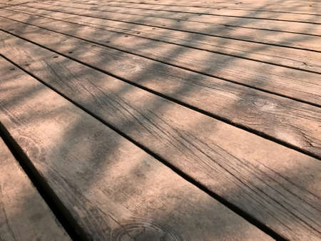 Brown wooden stage floor with woodgrain detail with tree shadow