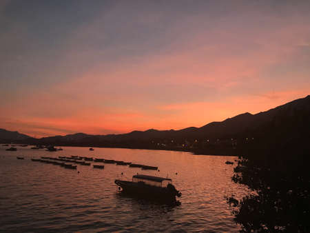 fishing boat, sea and the mountain  at sunsetの写真素材