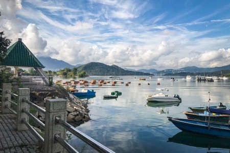 The mountain, blue sky, boats, yacht and sailboats on the lake