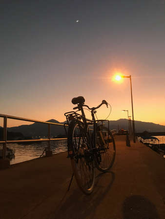 Retro bicycle, fence and gradient sunsetの写真素材