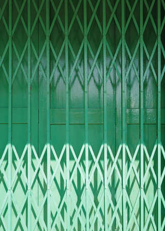 The vertical traditional retro Hong Kong style green shop front building matel gate rolling door designの写真素材
