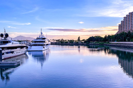 The white yacht boats in private dock, pier, gradient orange and blue sky at sunsetのeditorial素材