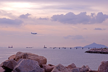 The horizontal bridge, aeroplane, clouds, bay, gradient sky, rocks natural photographyの写真素材