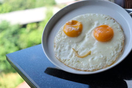 The fried eggs with smiling happy face at hotel's restaurantの写真素材