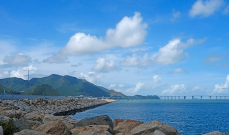 The natural landscape background, bridge, rocks, white clouds, ocean and coastlineの写真素材