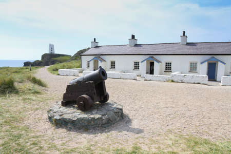 Pilot cottages and warning cannon on Llanddwn Island, Anglesey, Wales.のeditorial素材