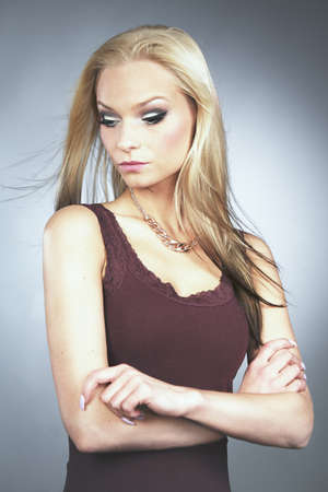 Blonde young woman posing in studio for portraitの写真素材