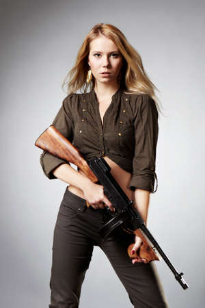 Mafia style fashion studio portrait - nice young woman posing with \"Tommy\" gun for figure and portrait photos in retro criminal style.の写真素材