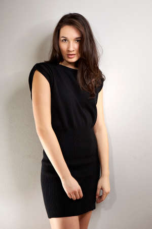 Cross-breed Euro/Asian long hair brunette girl posing in studio for portraits in several dress styles.の写真素材
