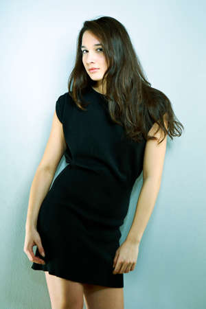 Cross-breed Euro/Asian long hair brunette girl posing in studio for portraits in several dress styles.の写真素材