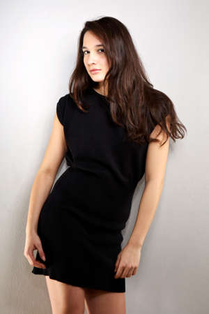 Cross-breed Euro/Asian long hair brunette girl posing in studio for portraits in several dress styles.の写真素材