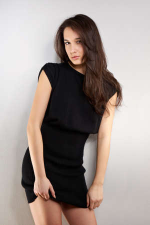 Cross-breed Euro/Asian long hair brunette girl posing in studio for portraits in several dress styles.の写真素材