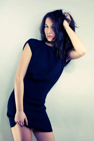 Cross-breed Euro/Asian long hair brunette girl posing in studio for portraits in several dress styles.の写真素材