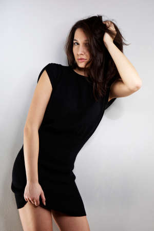 Cross-breed Euro/Asian long hair brunette girl posing in studio for portraits in several dress styles.の写真素材
