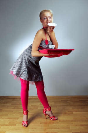 Young woman in retro style of fashion doll - housewife on interior location posing in various dresses.の写真素材