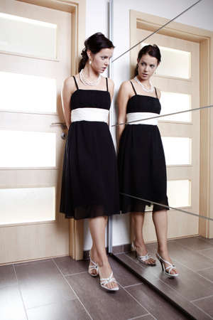 Woman at home posing in several rooms and positions for fashion and glamour photos in some dress styles.の写真素材