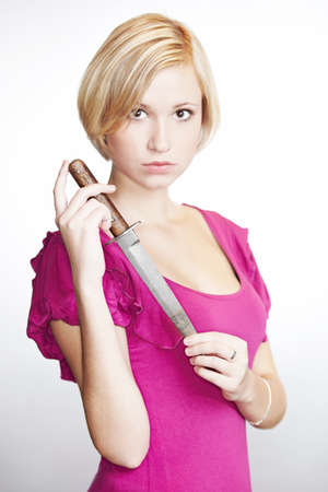 Young blonde beauty holding dangerous daggerの写真素材