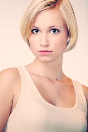 Blonde young pretty girl posing in studio for portrait photos in white A shirtの写真素材