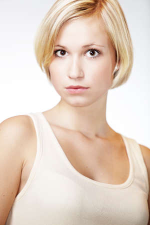 Blonde young pretty girl posing in studio for portrait photos in white A shirtの写真素材