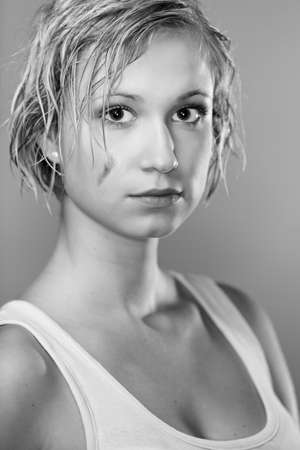 Dirty and wet hair nice blonde girl posing in studio for personal portraits.の写真素材