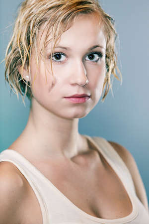 Dirty and wet hair nice blonde girl posing in studio for personal portraits.の写真素材