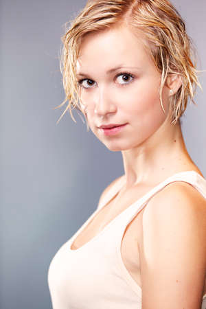 Dirty and wet hair nice blonde girl posing in studio for personal portraits.の写真素材