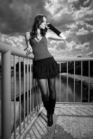 Nice redhair lady posing in summer light on outdoor location - river floodgate in several dress styles.の写真素材
