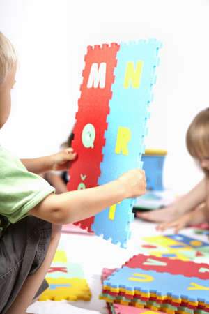 Children at play with set of rubber foam toys in studio on white backgroundの写真素材