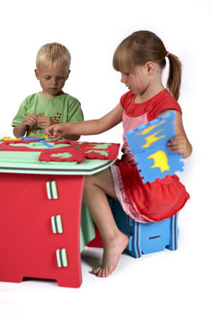 Children at play with set of rubber foam toys in studio on white backgroundの写真素材