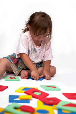 Children at play with set of rubber foam toys in studio on white backgroundの写真素材