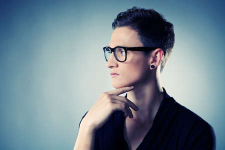 Young man posing in studio for personal and fashion portraits in glasses.の写真素材