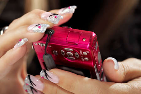 Making nails - applying gels and colors - electronics in fingersの写真素材