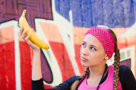 Young woman posing in city park and various locations in dress of pink shirt, hat, etc.の写真素材