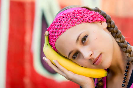 Young woman posing in city park and various locations in dress of pink shirt, hat, etc.の写真素材