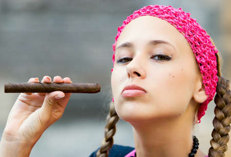 Young woman posing in city park and various locations in dress of pink shirt, hat, etc.の写真素材