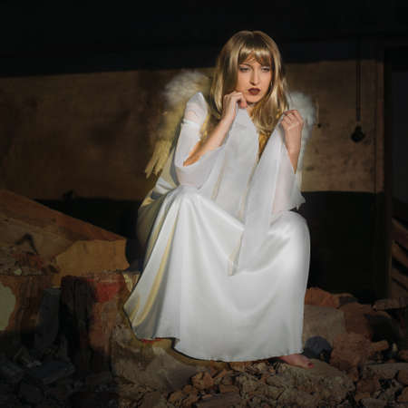 Angels on Earth! Lady posing with angel wings in ruins of the cityの写真素材
