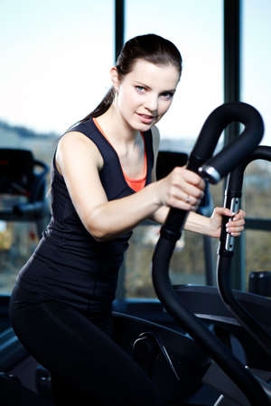 Young female model relaxing and exercising in modern fitness center in Prague.