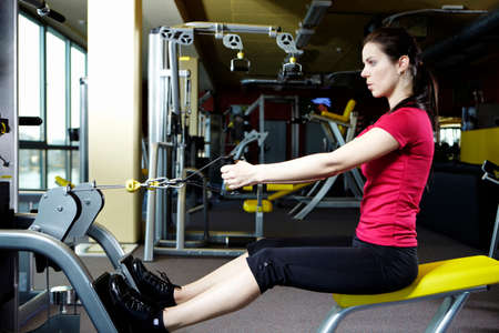 Young female model relaxing and exercising in modern fitness center in Prague.