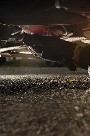 Plastic explosive bomb under car outdoor on parking placeの写真素材