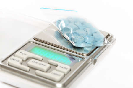 Pills of MDMA synthetic drugs on small digital scaleの写真素材
