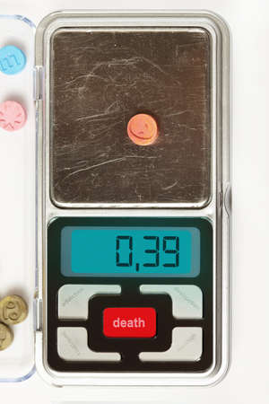 Pills of MDMA synthetic drugs on small digital scaleの写真素材