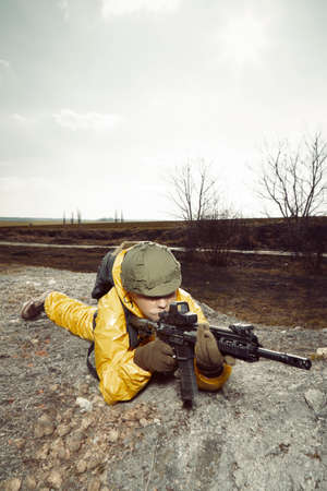 Freak gunman afraid of atomic war in yellow overall pointing on some target