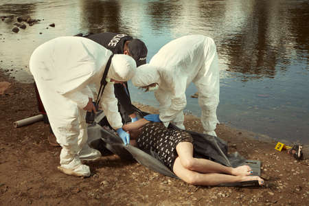 Woman found drowned on river bank in city placed in body bag for transportration