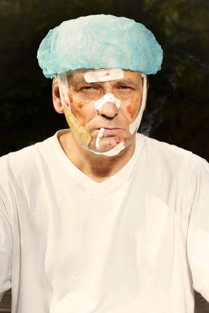Wounded and treated man relaxing after accident on park bench