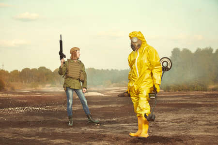 Specialist in chemical protective suit localizing and pick up artillery grenade on field