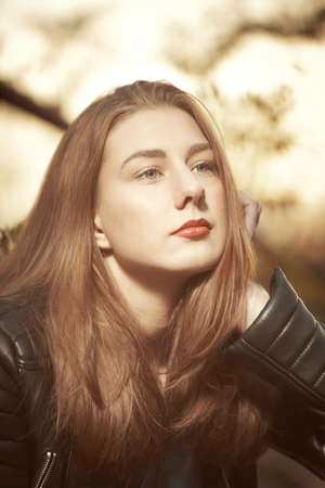Pretty brunette young woman posing in autumn late sun