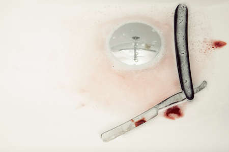 Razor with drops of blood in wash basin as result ob bad shaving