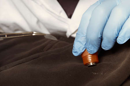 Proccess of collecting possible gunshot residue from suspected clothes in police labの写真素材
